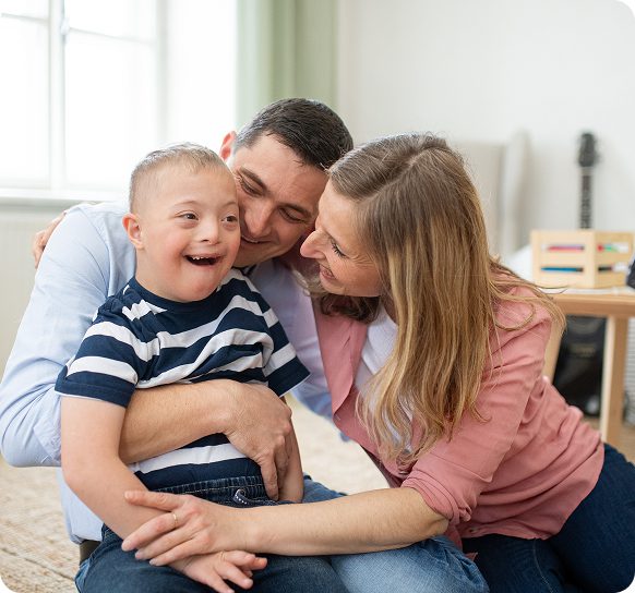 Loving family embraces smiling young boy